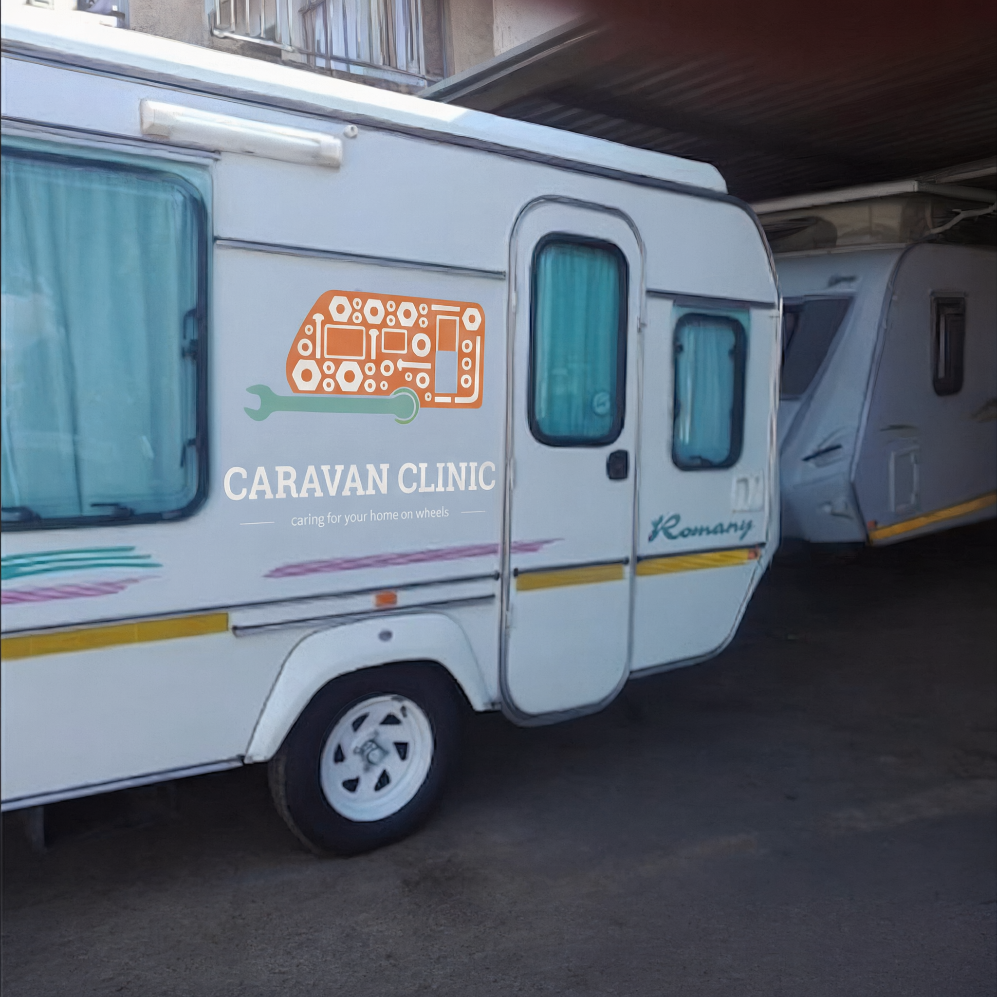 Caravan Clinic branded caravan parked at the workshop